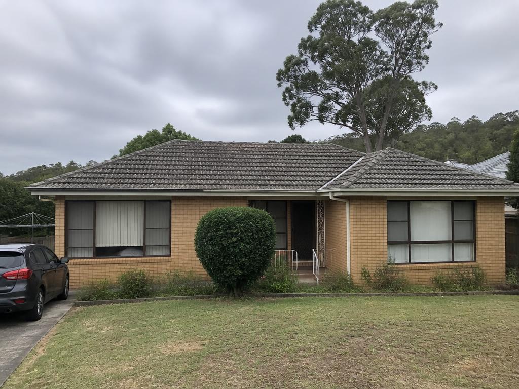 Faded concrete tile roof streaked with mould and lichen, with tired ridge capping